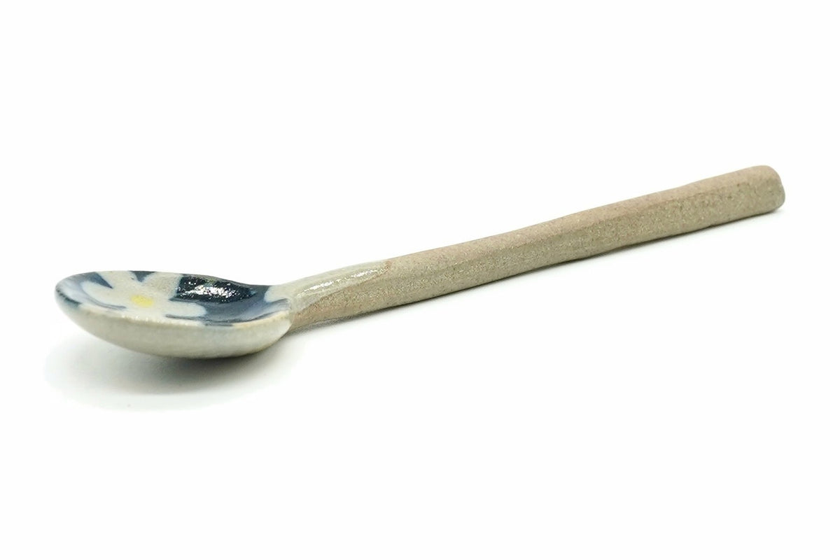 Aobana Ceramic Tea Spoon, a small spoon with a white blossom on navy inside the bowl, a pale outer glaze and a long unglazed clay handle, seen from the side