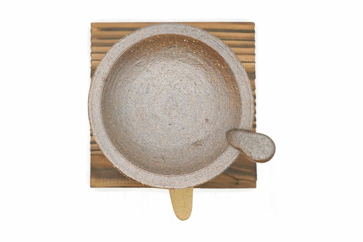 Kakewake Cha-kōro from above, the grey-brown tab-handled dish on top, shown on a wooden board that is not included
