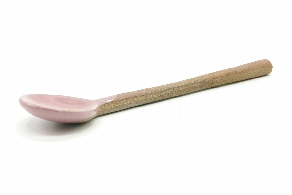 Momo Ceramic Tea Spoon, a small spoon with a pink glazed bowl and a long unglazed clay handle, seen from the side