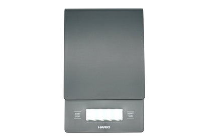 Hario V60 Drip Scale in black, top view showing the weighing platform, timer and weight display, and the start, stop and tare buttons