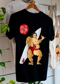 A black organic cotton t-shirt with a graphic print of a Japanese sumo wrestler holding a surfboard, with EdoMatcha logo.