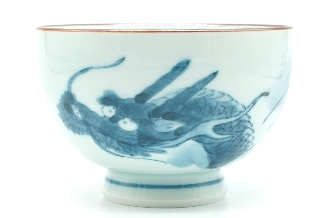 Dragon Yunomi, a small white Hasami porcelain teacup with a blue dragon design, a brown rim line and blue rings on the foot