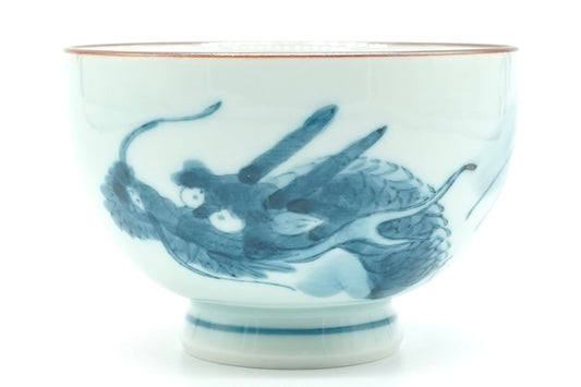 Dragon Yunomi, a small white Hasami porcelain teacup with a blue dragon design, a brown rim line and blue rings on the foot