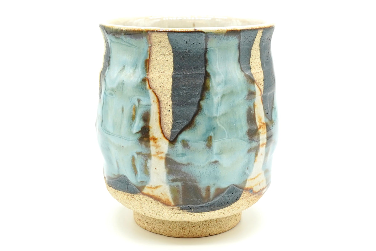 Sushi Yunomi, a tall Mino ware teacup with pale blue and cream glaze poured over dark iron-brown patches on sandy clay