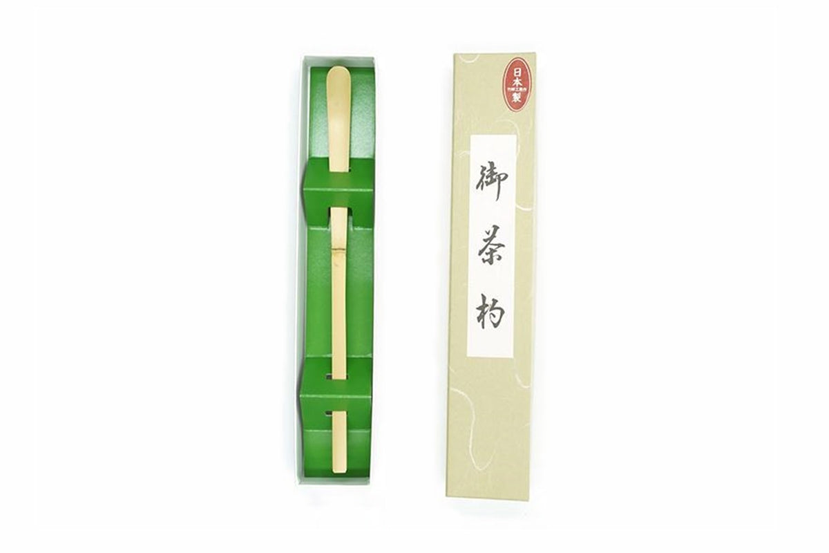 Chashaku bamboo matcha scoop in its green tray beside its labelled box