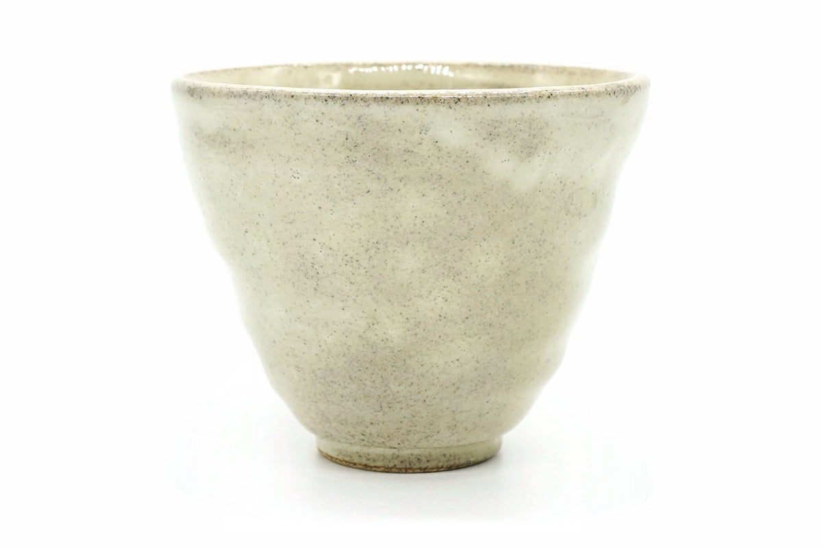 Daikon Yunomi, a speckled cream Mino ware teacup with gently dimpled sides and a wide rim, front view