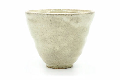 Daikon Yunomi, a speckled cream Mino ware teacup with gently dimpled sides and a wide rim, front view