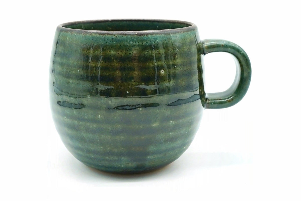Fukamidori Yunomi, a round Mino ware mug in a deep green glaze with fine horizontal rings and a loop handle on the right