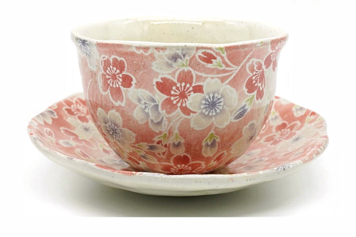 Sakura Yunomi, a Mino ware cup covered in pink and white cherry blossoms on a red ground, on its matching saucer