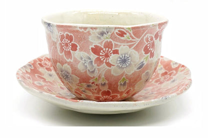Sakura Yunomi, a Mino ware cup covered in pink and white cherry blossoms on a red ground, on its matching saucer