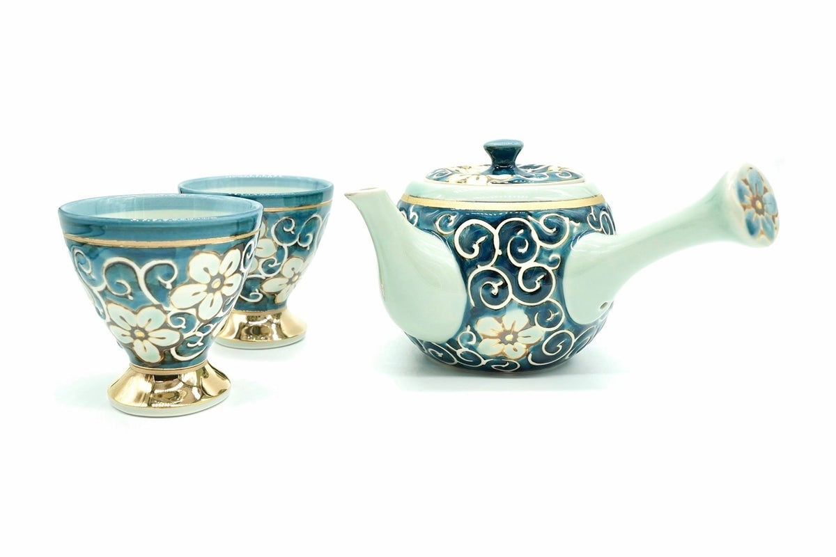 Hana-Karakusa Japanese Tea Set: the blue kyusu with white scrolls and pale flowers beside its two footed cups on gold-coloured feet