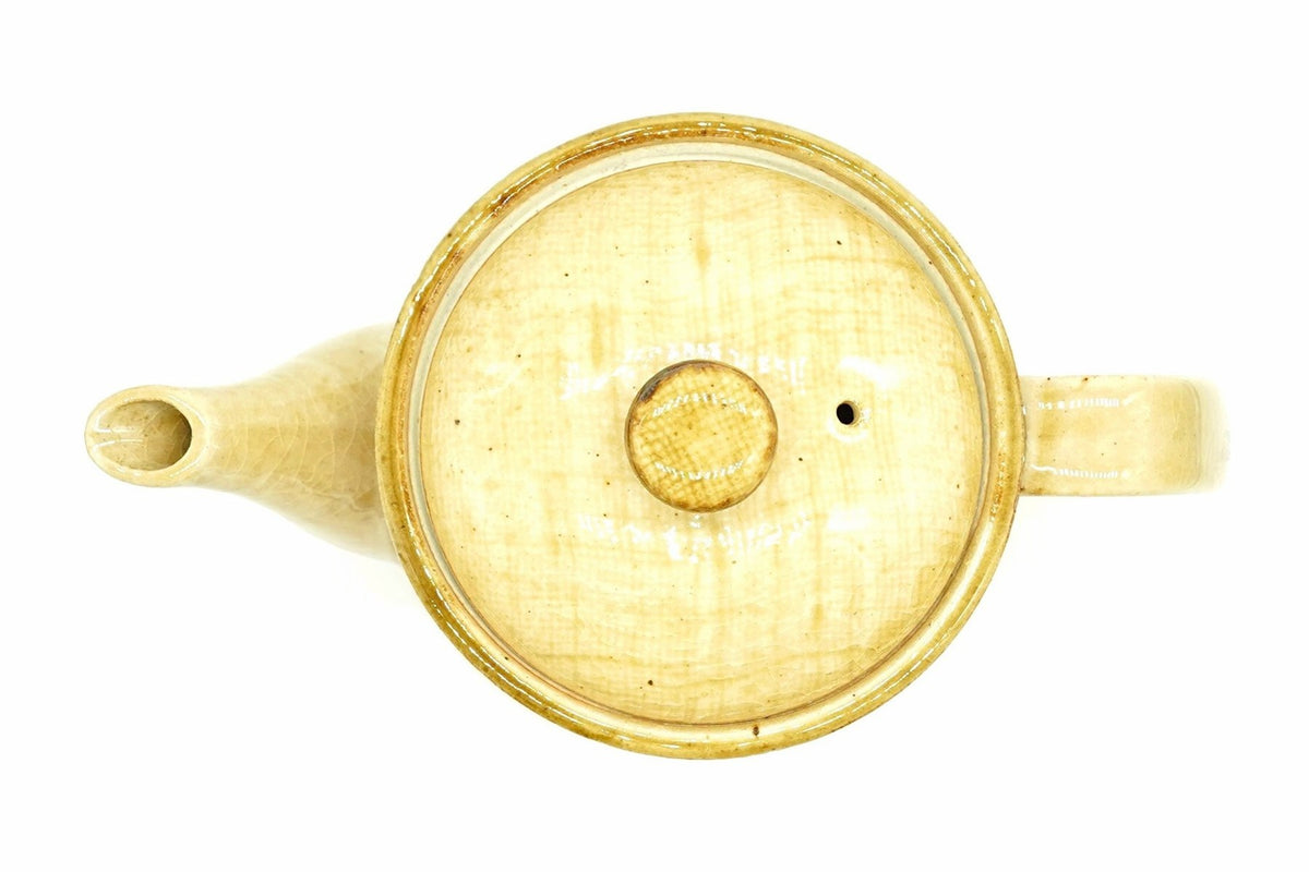Hanabira Kyusu from above with the lid on, the round straw-beige lid and its amber knob between the spout and the handle