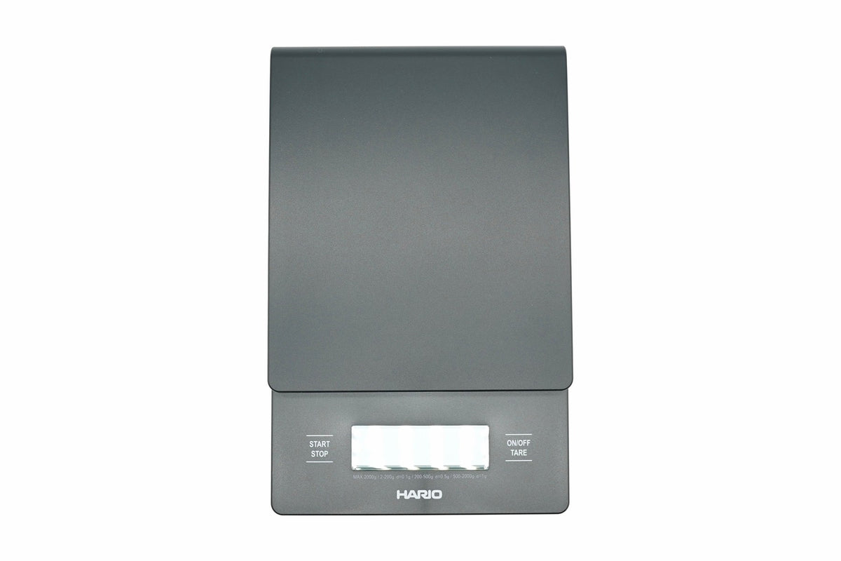 Hario V60 Drip Scale in black, top view showing the weighing platform, timer and weight display, and the start, stop and tare buttons