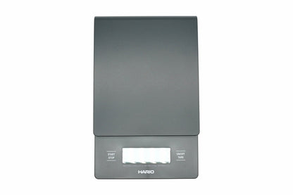 Hario V60 Drip Scale in black, top view showing the weighing platform, timer and weight display, and the start, stop and tare buttons