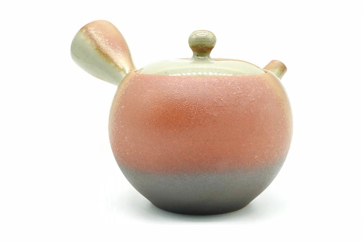 Isshin Kyusu, a Tokoname teapot with a rough coral-red body over a grey-black base and a pale green lid