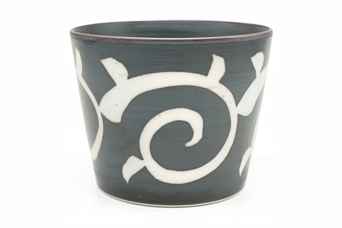 Karakusa Yunomi, a dark grey teacup with a white arabesque scroll pattern, front view