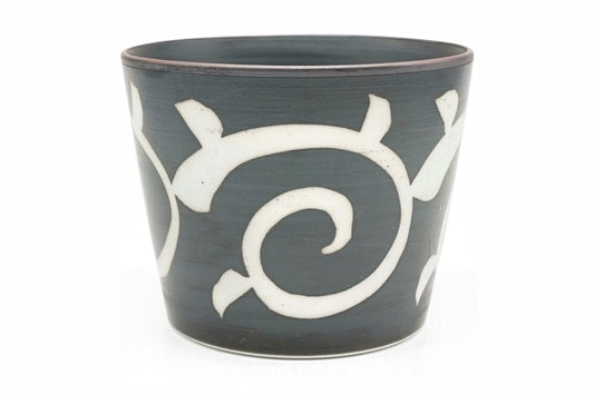 Karakusa Yunomi, a dark grey teacup with a white arabesque scroll pattern, front view