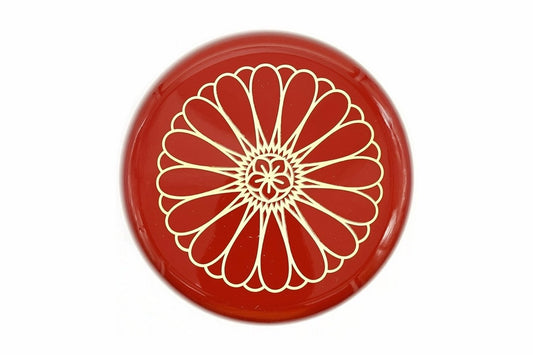 Lid of the red Kikumon Natsume from above, filled by one large gold chrysanthemum crest