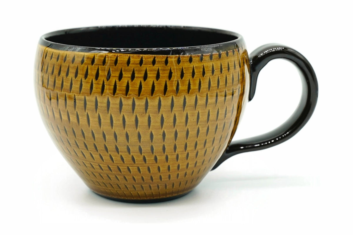 Kinpai Yunomi, a wide Mino ware cup in an amber-gold glaze cut with rows of dark marks, with a black handle, front view, EdoMatcha Sydney