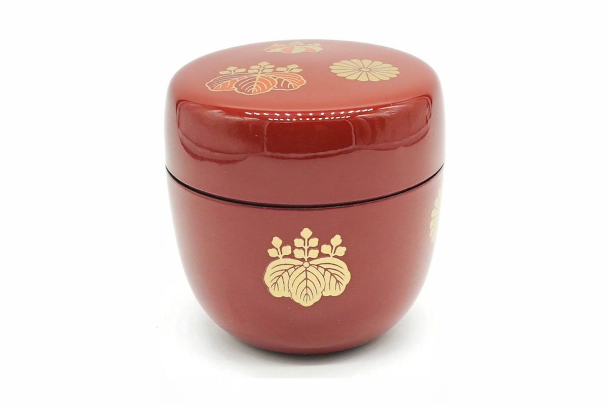 Kōdaiji Natsume in red, a glossy matcha caddy with a gold paulownia crest on the body and small gold crests on the lid