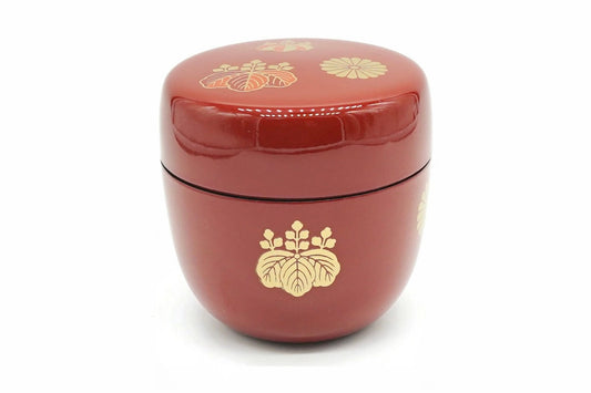 Kōdaiji Natsume in red, a glossy matcha caddy with a gold paulownia crest on the body and small gold crests on the lid
