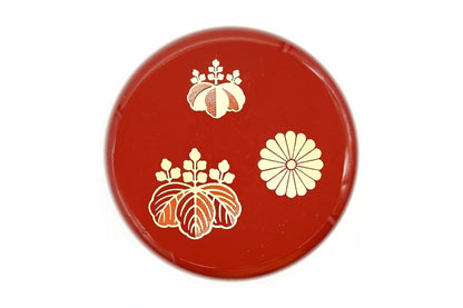 Lid of the red Kōdaiji Natsume from above, two gold paulownia crests and a gold chrysanthemum crest