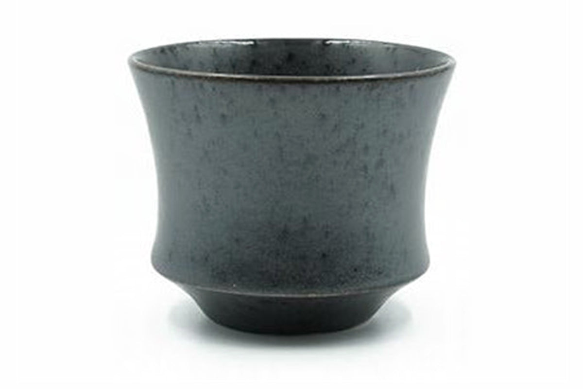 Kuro Yunomi, a matte charcoal-black Mino ware teacup flaring from a stepped foot, front view