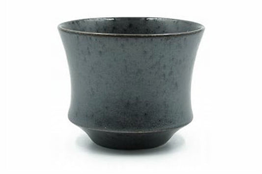 Kuro Yunomi, a matte charcoal-black Mino ware teacup flaring from a stepped foot, front view