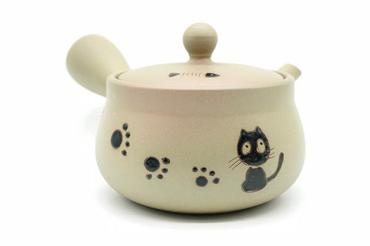 Maneki-Neko Kyusu, a pale beige Tokoname teapot painted with a black cat and paw prints, side view, EdoMatcha Sydney