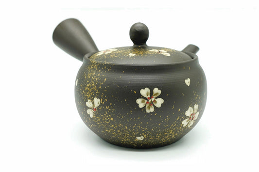 Nadeshiko Kyusu, a black Tokoname teapot flecked with gold and painted with white dianthus flowers, side view