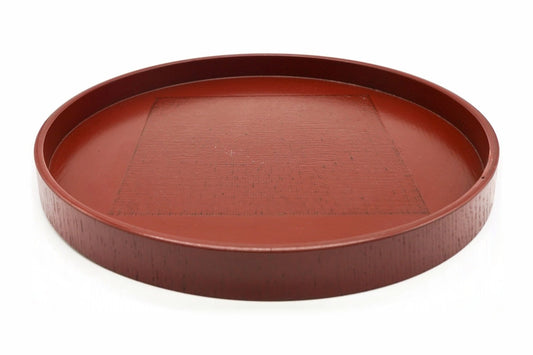 Negoro Maru-bon, a round red tea tray with a low straight rim and a textured square in the centre, seen from the side