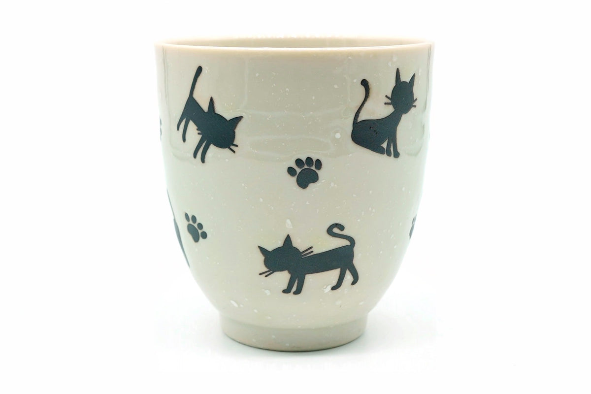 Neko Yunomi, a pale Mino ware teacup with black cat silhouettes and paw prints, front view