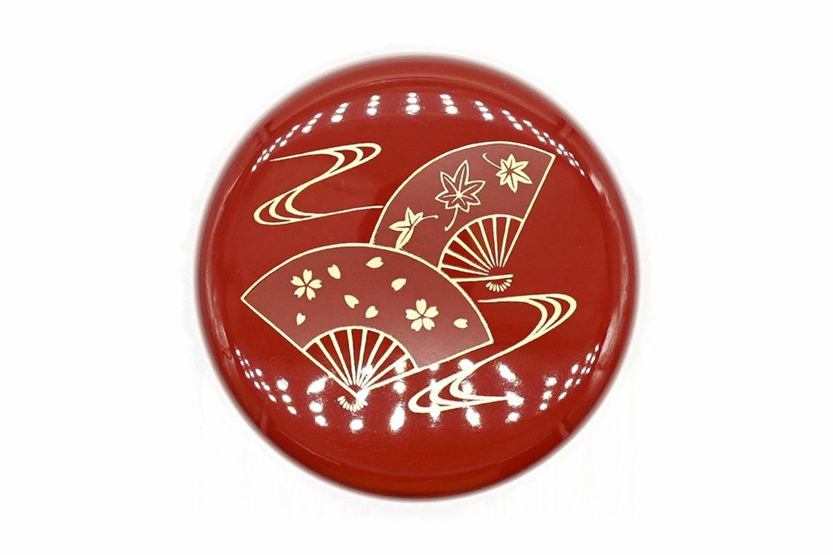 Lid of the red Ōgi Natsume from above, two folding fans, one with cherry blossoms and one with maple leaves, over gold flowing water
