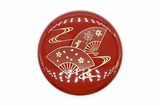 Lid of the red Ōgi Natsume from above, two folding fans, one with cherry blossoms and one with maple leaves, over gold flowing water
