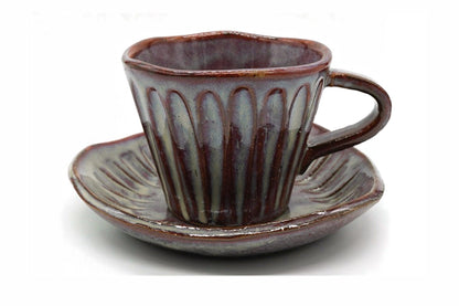 Shibu Yunomi, a fluted Mino ware cup with a handle in a mottled purple-brown and grey-blue glaze, on its saucer
