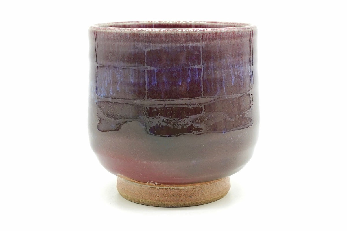 Shinsha-Nagashi Yunomi, an Arita ware teacup in a flowing copper-red glaze shading from deep wine to violet, with a bare sandy foot