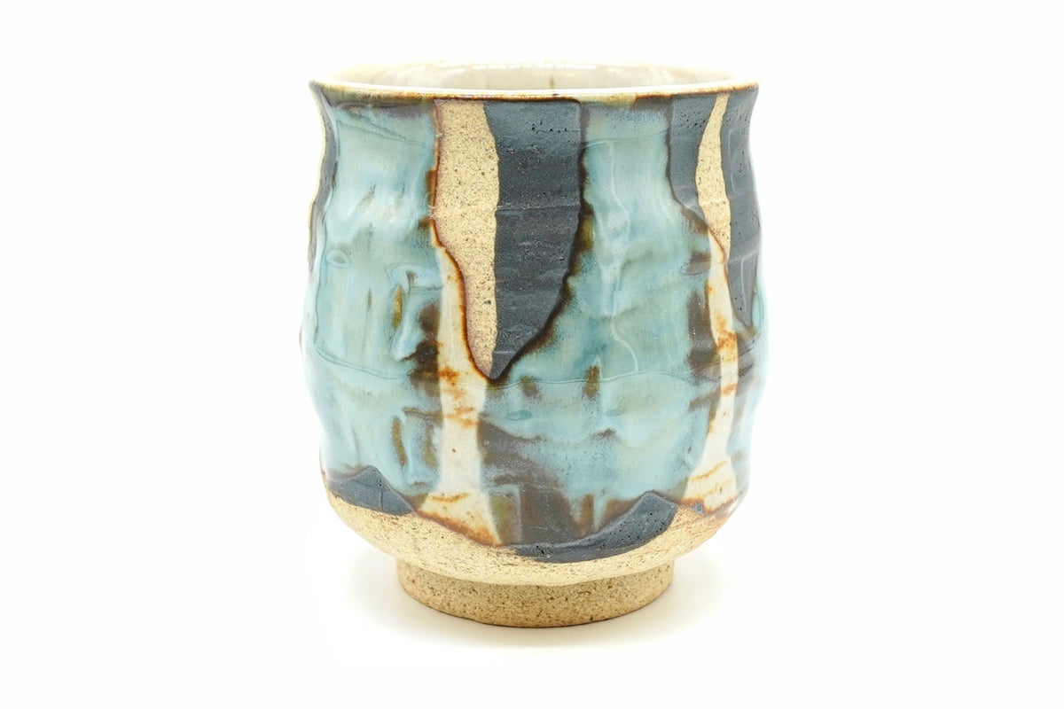 Sushi Yunomi, a tall Mino ware teacup with pale blue and cream glaze poured over dark iron-brown patches on sandy clay