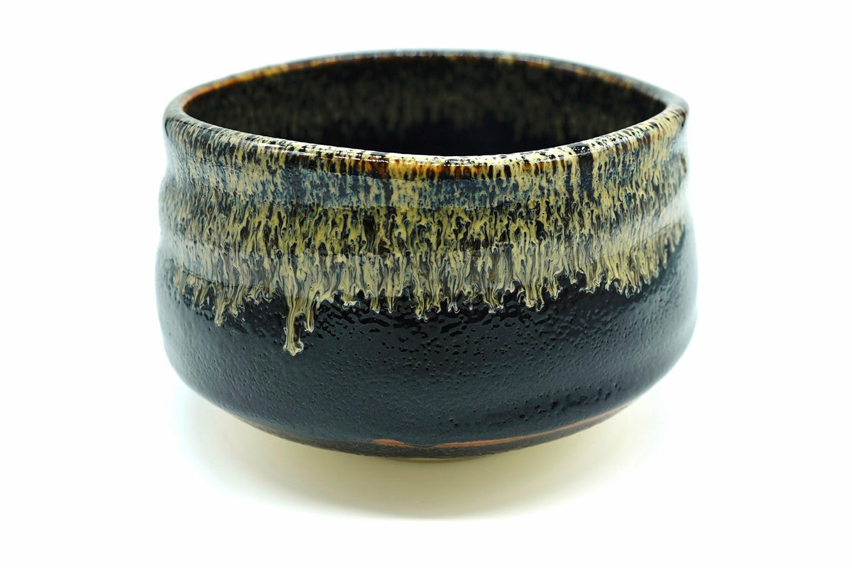 Take Chawan, a glossy black Mino ware matcha bowl with straw-gold glaze dripping from the rim, front view