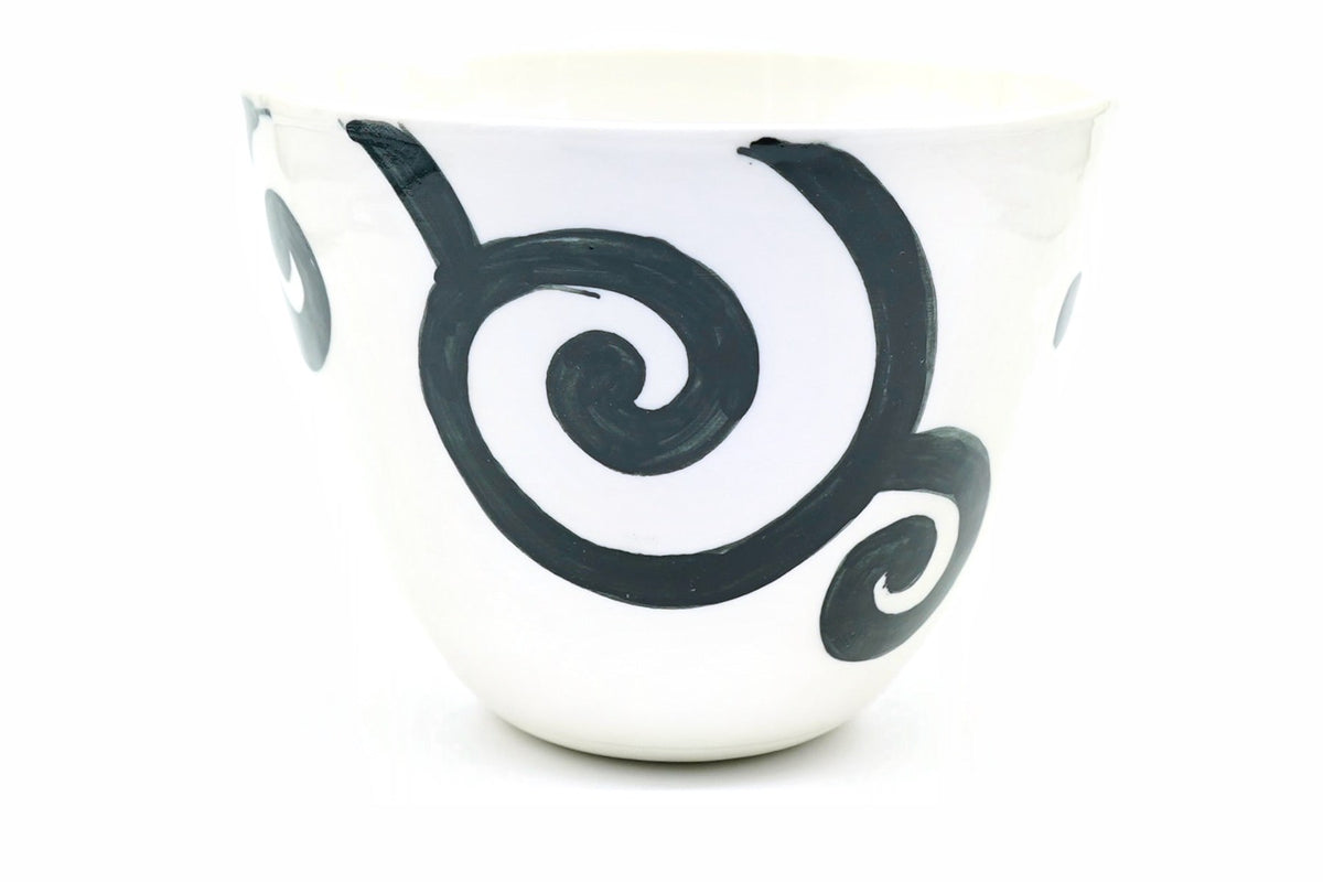 Uzumaki Yunomi, a wide white Hasami ware teacup with bold black spirals brushed around it, front view