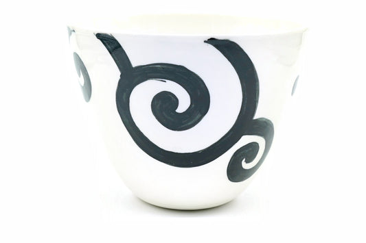 Uzumaki Yunomi, a wide white Hasami ware teacup with bold black spirals brushed around it, front view